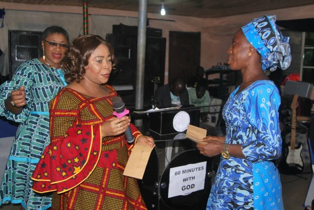 Women presenting an envelope during a 60 Minutes with God gathering