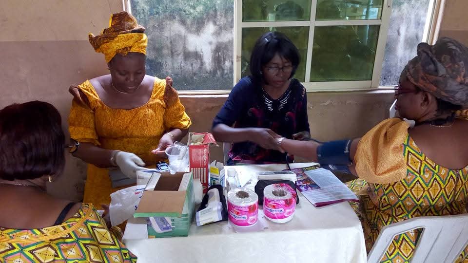Women supporting a community health screening with medical supplies
