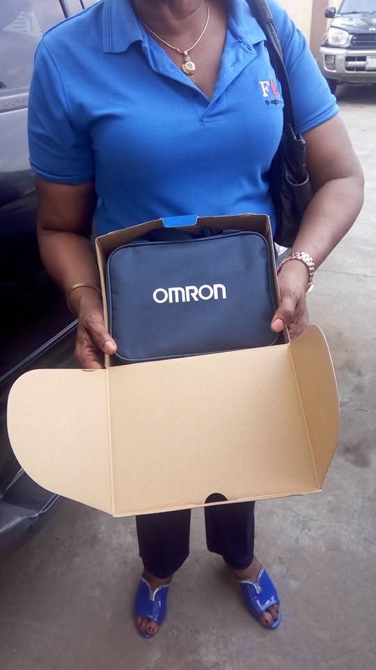 A ministry member holding a blood pressure monitor during health outreach