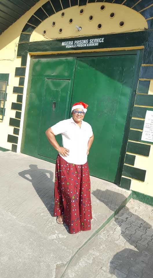 A ministry member standing beneath the Nigeria Prisons Service sign at the female prison in Kirikiri, Lagos